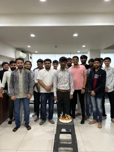 Team celebrating an employee’s birthday in the office with cake and decorations.