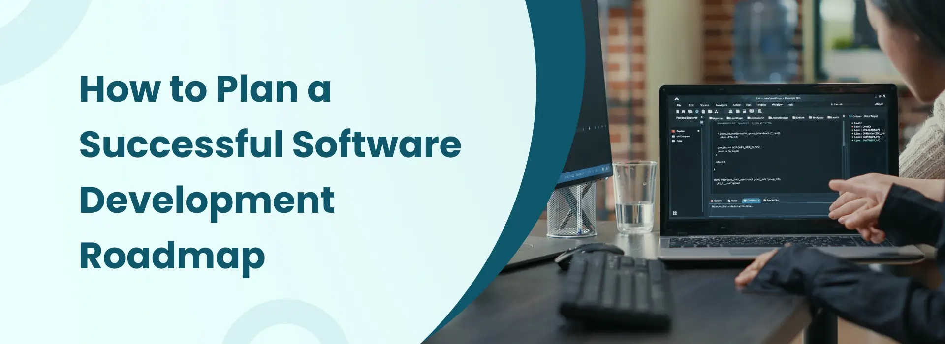 Software developers planning a project roadmap while reviewing code on a laptop in a modern office workspace.