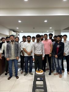 Team celebrating colleague’s birthday at the office with cake and smiles